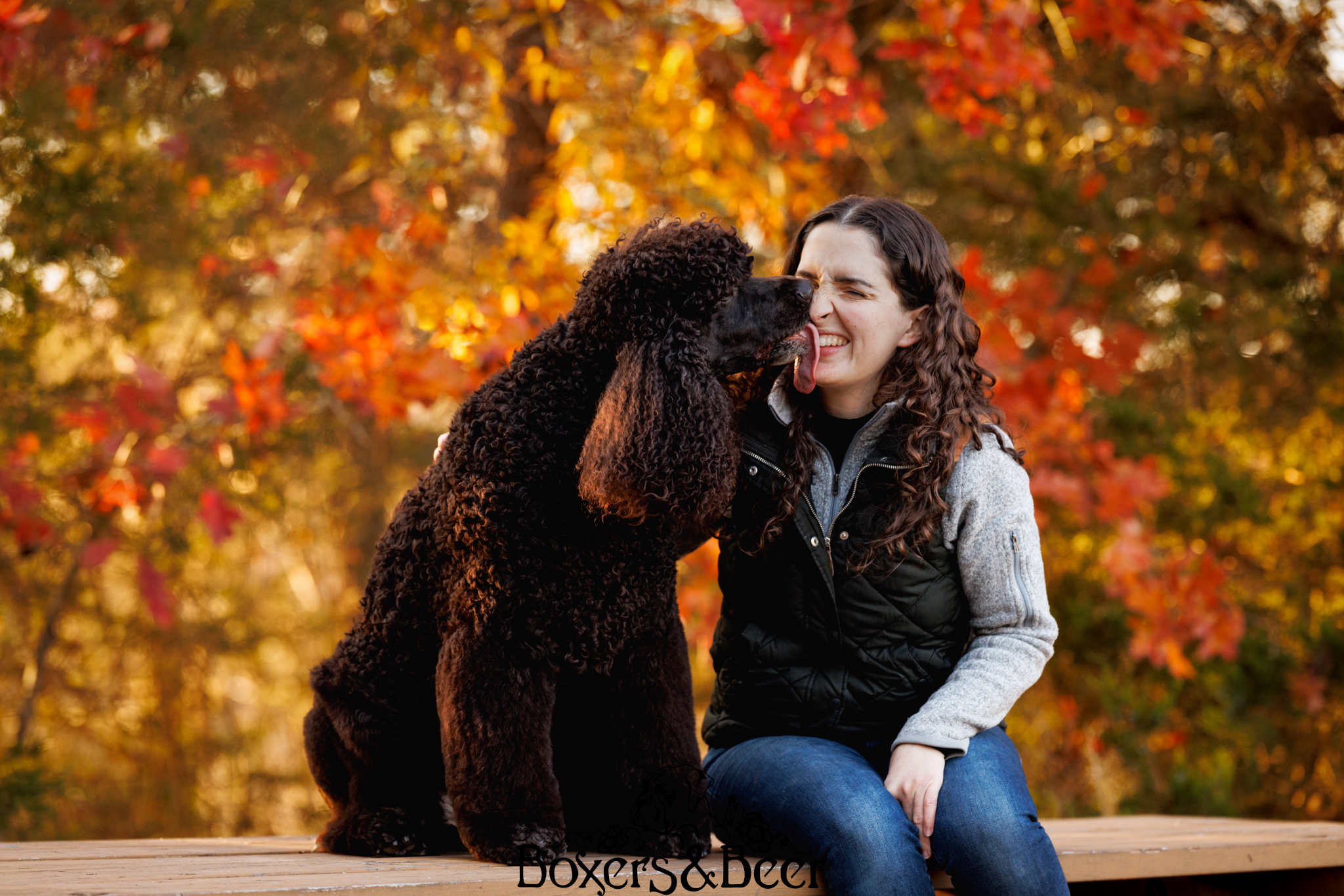 Owner of Irish Water Spaniel posing and getting kisses from her dog